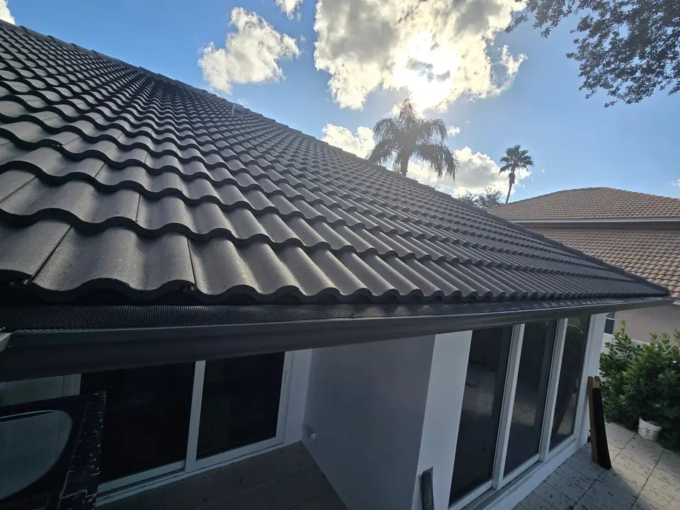 A dark gutter under a black concrete tile roof
